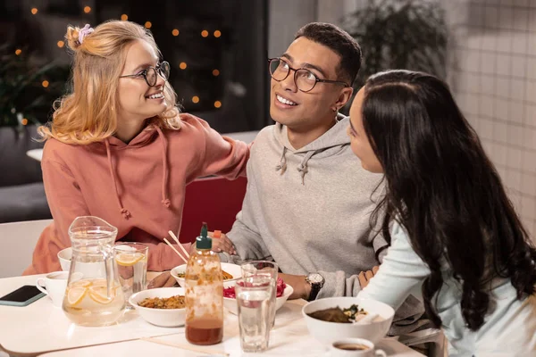 Drie vrienden zitten in Cafe en dromen van gezamenlijke rest tijdens het eten. — Stockfoto