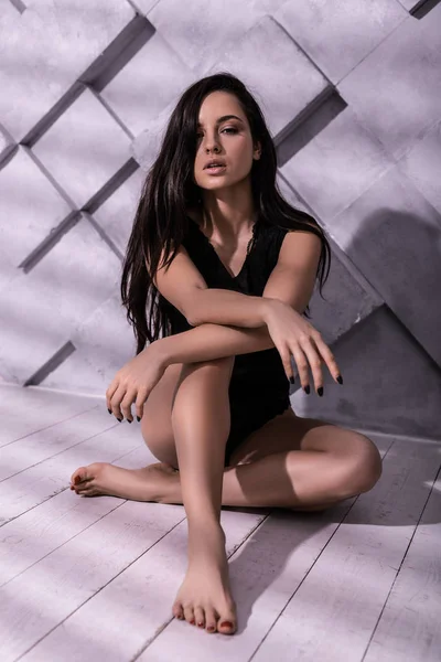 Hermosa postura maniquí en estudio de fotos con fondo de patrón lila —  Fotos de Stock