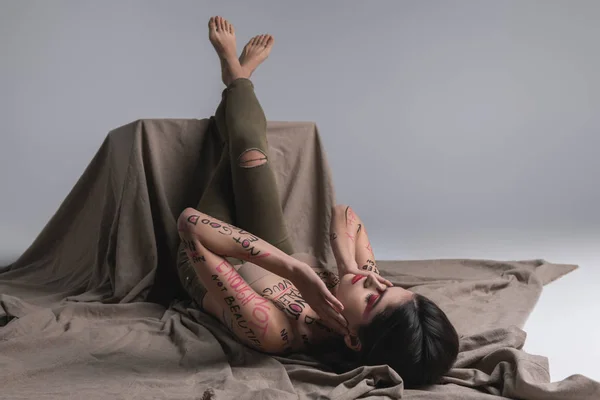台座に足を置くスキニー ジーンズの若いブルネットかわいいスリムなモデル — ストック写真