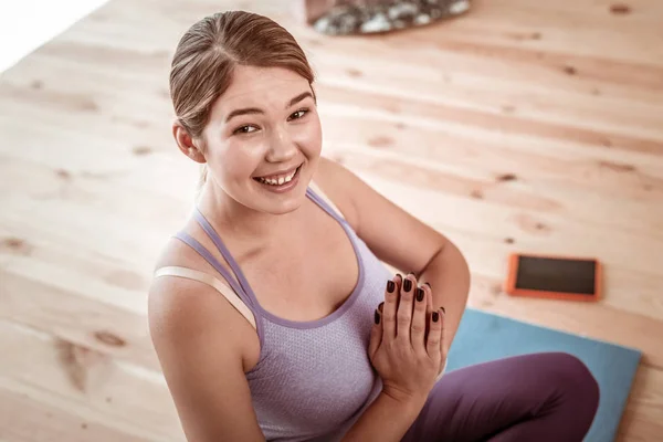 Laughing beaming woman having yoga training at home