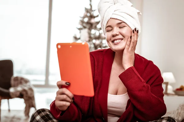 Pleasant joyful woman having enjoyable conversation through tablet — Stock Photo, Image