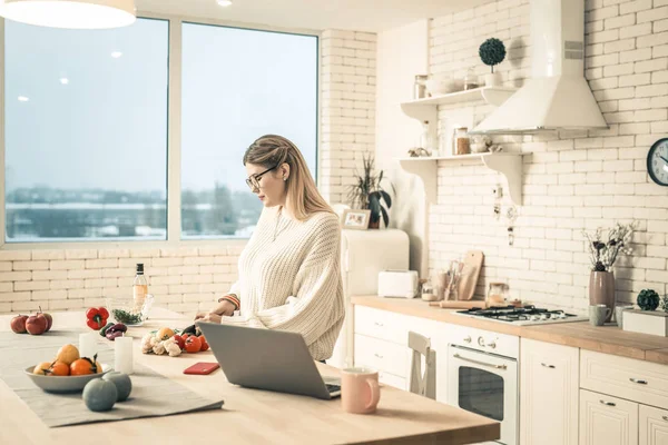 Attenta giovane donna che cucina in cucina ordinata — Foto Stock