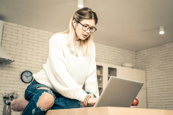Középpontjában a vezeték nélküli fejhallgató látszó laptop képernyőn elfoglalt hölgy — Stock Fotó