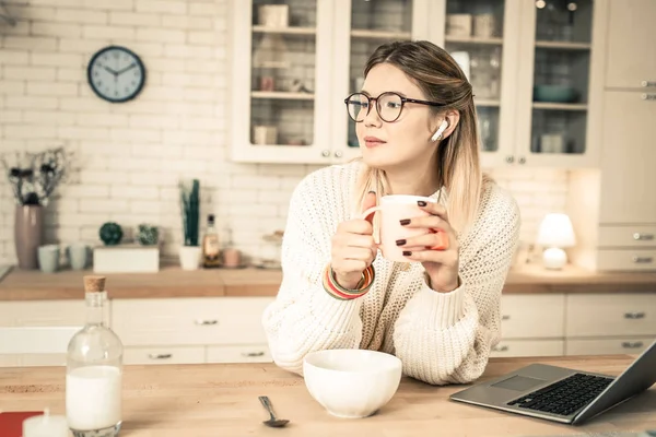 Спокійна доброзичлива жінка в чистих окулярах тримає склянку чаю — стокове фото