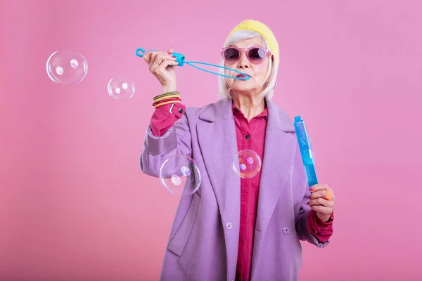 Anciana jugando con burbujas de jabón mientras nunca envejece — Foto de Stock