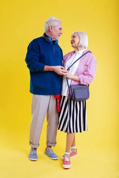 Moderna pareja jubilada vistiendo zapatillas de deporte mirándose — Foto de Stock