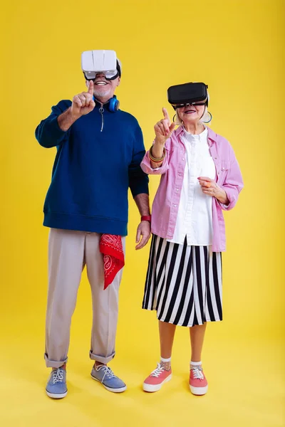 Elegante pareja jubilada que se siente involucrada en el estudio de la realidad virtual — Foto de Stock