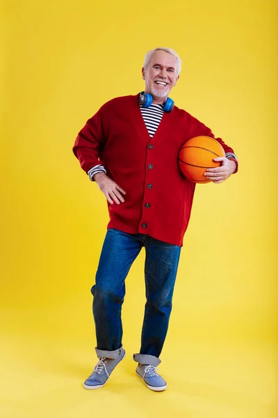 Důchodce na sobě džíny vede zdravého životního stylu a milující basketbal — Stock fotografie