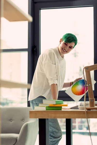 Mulher alegre agradável olhando para a roda de cores — Fotografia de Stock