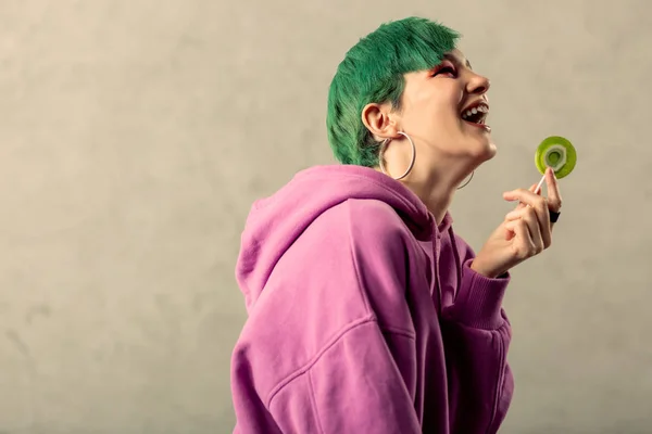 Deliciosa mujer de pelo verde sosteniendo una piruleta dulce — Foto de Stock