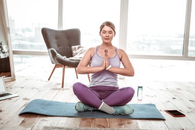 Lotus duruş mavi mat üzerinde oturan meditasyon rahat kadın
