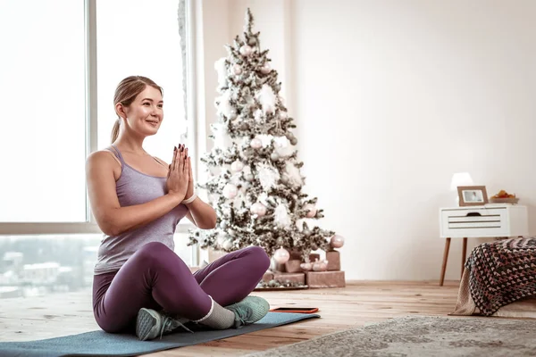 Cheerful sportive lady wearing violet leggings and blue sneakers