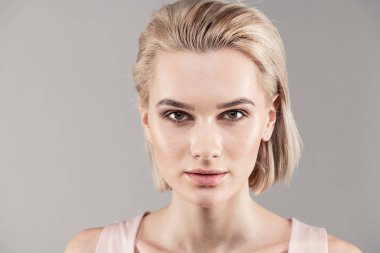 Kısa saçlı kadın kararlı kameraya bakarak çekici