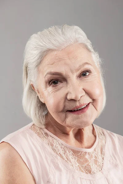 Donna sorridente dai capelli grigi con taglio di capelli bob che indossa trucco leggero — Foto Stock