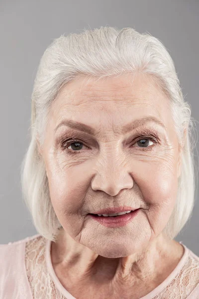 Alte grauhaarige Frau mit Bob-Frisur blickt direkt in die Kamera — Stockfoto