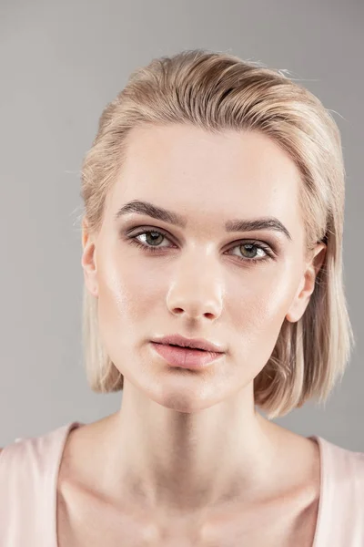 Atractiva jovencita con el pelo corto y rubio posando para el camarógrafo — Foto de Stock