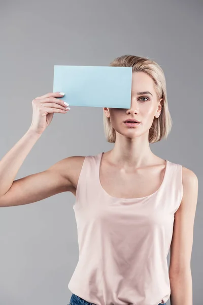 Tranquil neutral woman with blonde short hair wearing nude shirt — Stock Photo, Image