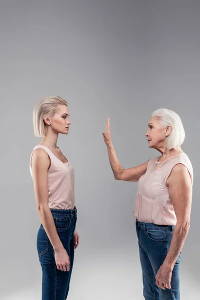 Decidida dama mayor fuerte levantando la mano mientras pide silencio — Foto de Stock