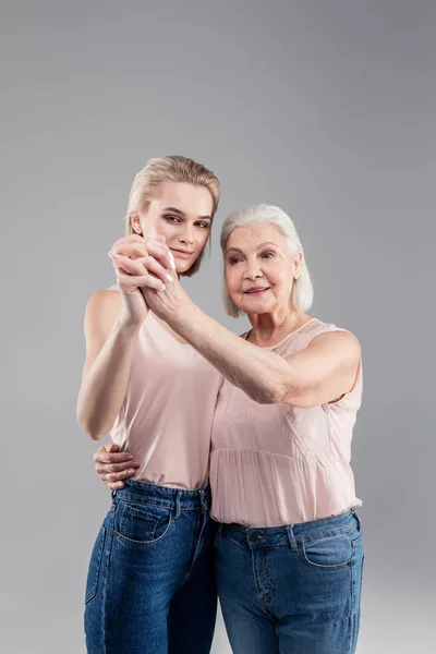 Ler gamla gråhåriga damen nära vackra dotter — Stockfoto