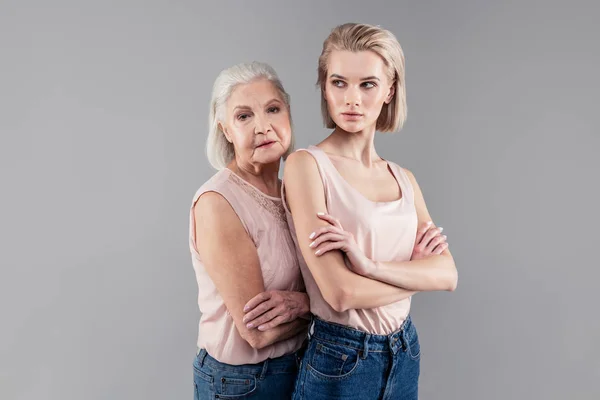 Senior de pelo gris madre apoyándose en su hija espalda — Foto de Stock
