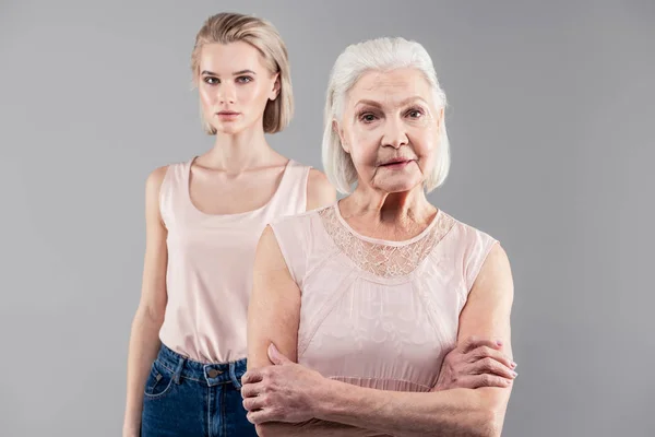 Preciosa anciana de pelo gris de pie en primer plano con las manos cruzadas — Foto de Stock