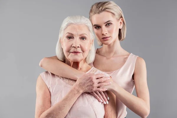 Aangename oude dame en haar aantrekkelijke blonde meisje weergeven van hun relaties — Stockfoto