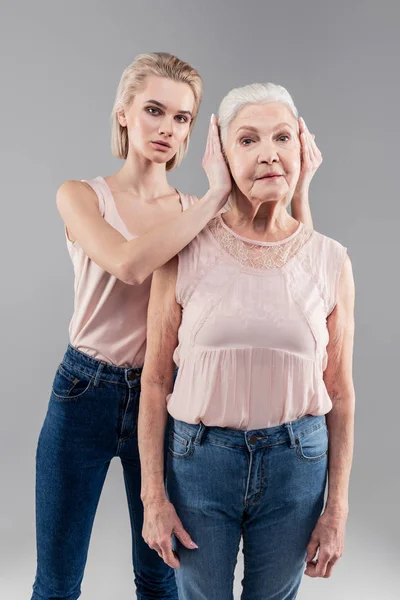 Resolute blonde guardian shutting up ears of motionless mother — Stock Photo, Image
