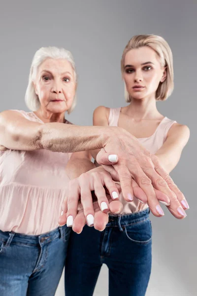 Mujer seria y guapa mostrando sus dedos cruzados con manicura — Foto de Stock