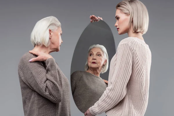 Bătrâna cu părul scurt care pozează în timp ce se verifică în oglindă — Fotografie, imagine de stoc