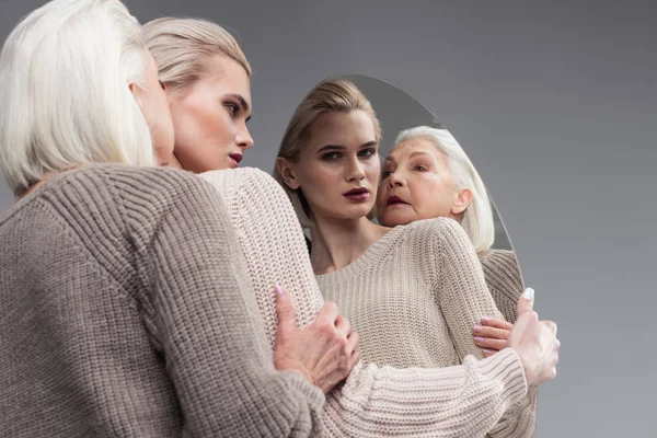 Aterradora madre de pelo gris tocando las manos de su hija — Foto de Stock