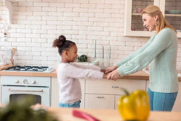 Madre e hija sintiéndose felices mientras bailan después del desayuno —  Fotos de Stock