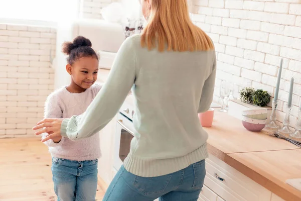 Cheerful funny mother and daughter dancing in the kitchen — Stock Photo, Image