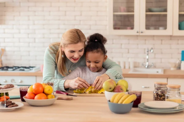 Curly filha gostando de cozinhar com sua mãe adotiva — Fotografia de Stock