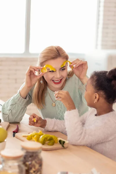 Mamma si diverte mentre taglia il pepe con il suo bambino adottivo — Foto Stock