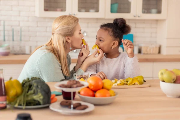 Glada mor och dotter som spelar ett spratt under matlagningen — Stockfoto