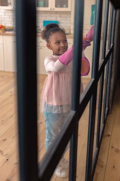 Αφροαμερικανός κοριτσάκι συναίσθημα που συμμετέχουν στον καθαρισμό τη γυάλινη πόρτα — Φωτογραφία Αρχείου