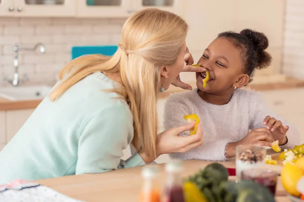 Rolig afroamerikansk flicka skrattar medan matlagning med mamma — Stockfoto
