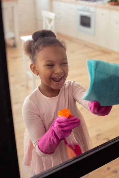 Grappig meisje lachen terwijl u geniet van haar moeder te helpen met het schoonmaken van — Stockfoto