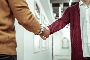 Beyaz gömlek ve bordo hırka tokalaşırken ofis çalışanı