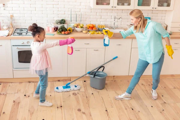 Mutter und Tochter spielen und haben Spaß beim Putzen — Stockfoto