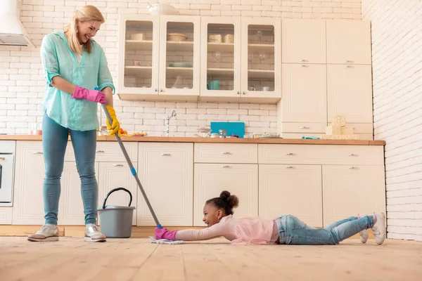 Matka se baví s dcerou při vytírání podlahy — Stock fotografie