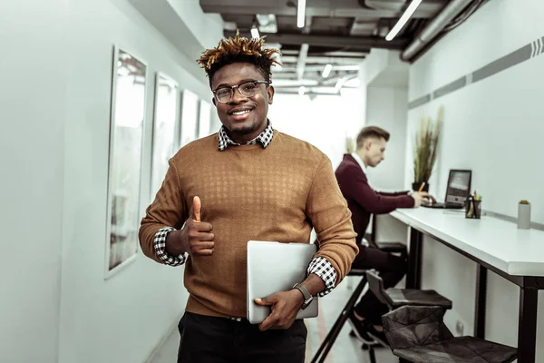 Sorrindo positivo cara de pele escura mostrando sua miniatura — Fotografia de Stock