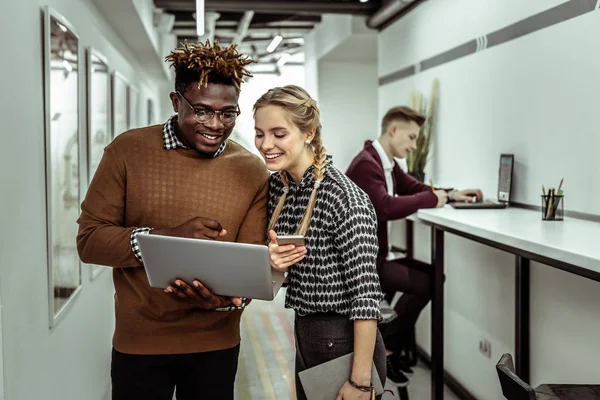 Lächelnder afrikanisch-amerikanischer Typ mit klarer Brille und Laptop — Stockfoto