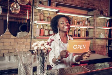 Çekici Afro-Amerikan çatı bar çalışan açık işareti elinde tutmak
