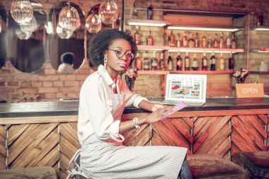 Ciddi Afro-Amerikan kıvırcık saçlı tablete tıklayarak alt bar