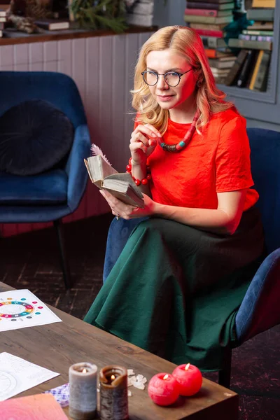 Loira de cabelos cartomante sentindo alegre leitura livro interessante — Fotografia de Stock