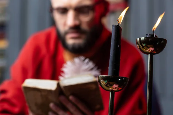 Κοντινό πλάνο του δύο κεριά στέκεται στο τραπέζι κοντά diviner ανάγνωση βιβλίων — Φωτογραφία Αρχείου