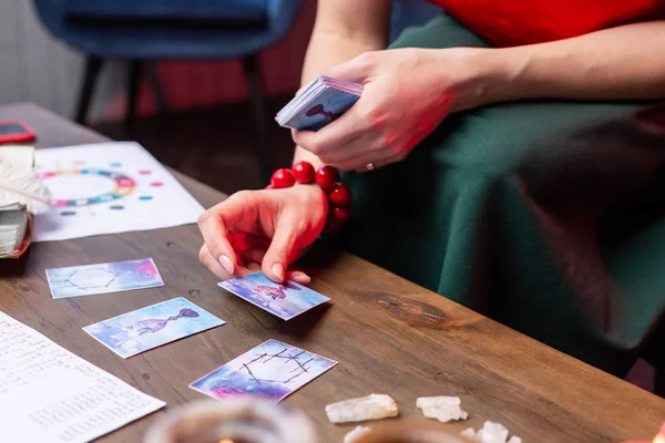 Ansicht von oben: Frau mit rotem Armband liest Orakelkarten — Stockfoto