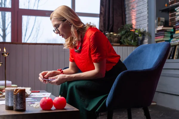 Mujer sentada en sillón y casa y prediciendo el futuro con tarjetas — Foto de Stock