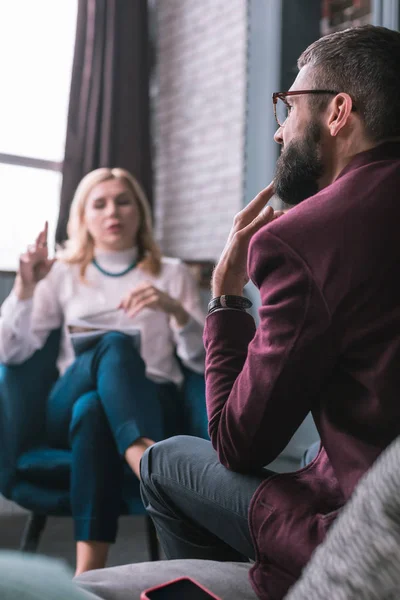 Vousatý muž cítí strach, vysvětlující problémy psycholog — Stock fotografie